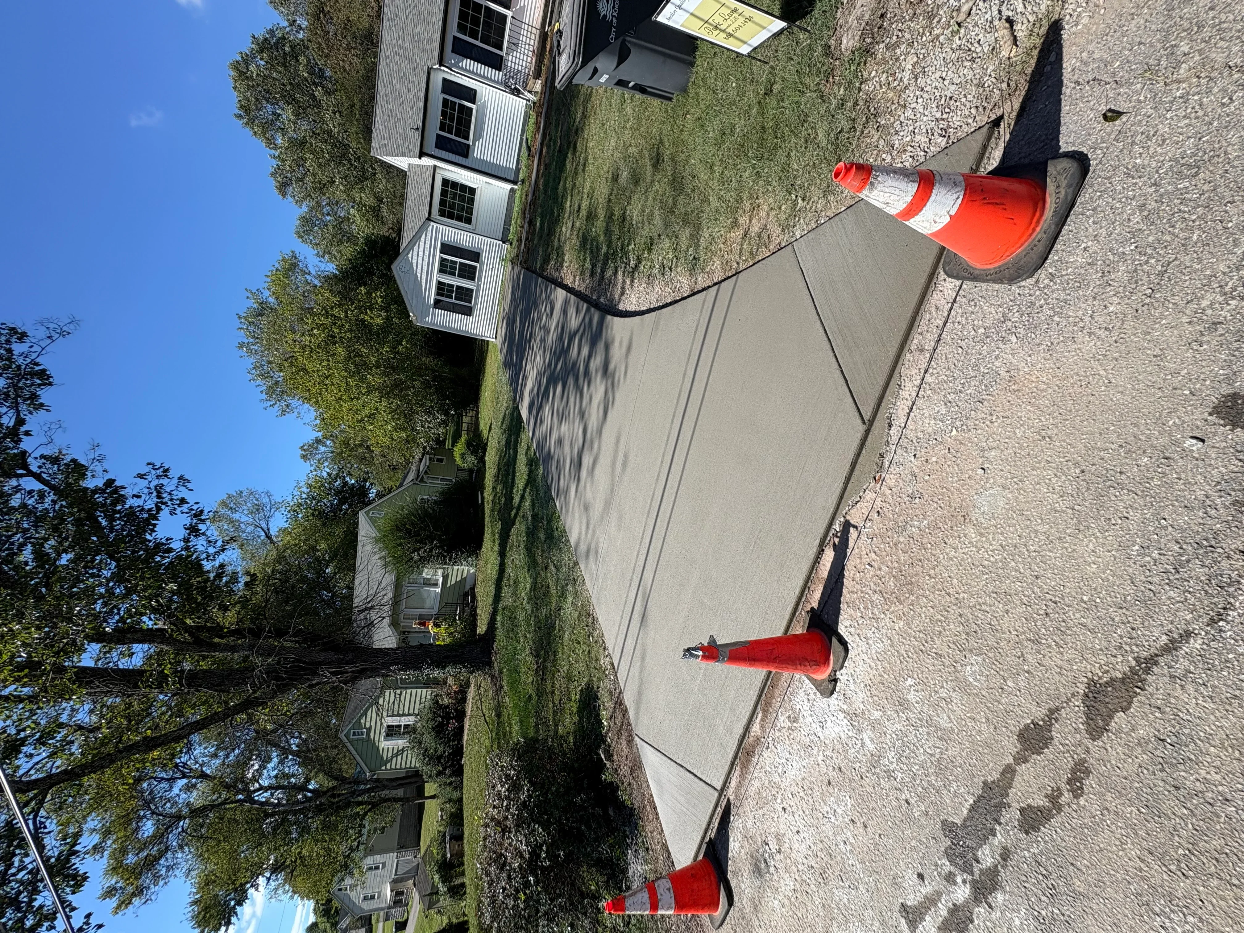 Newly installed concrete driveway with traffic cones and finished surface