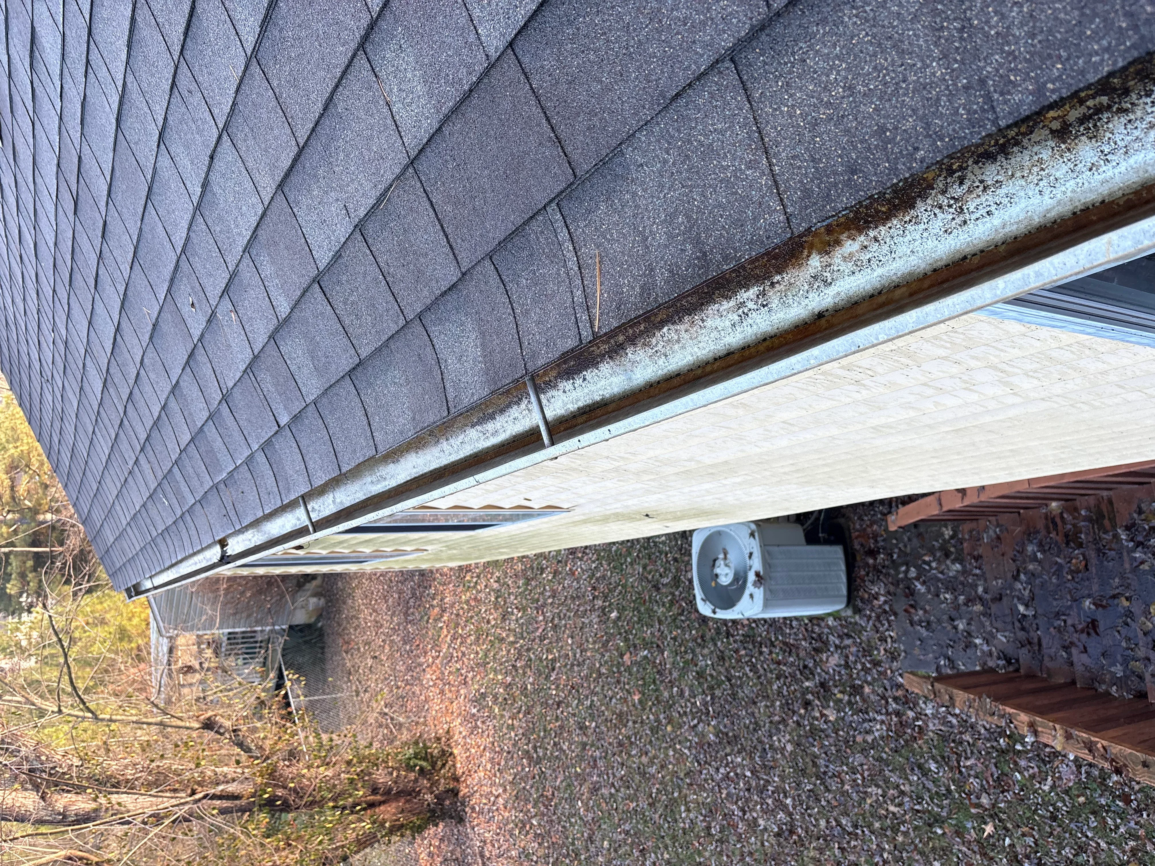 New aluminum gutter system installed on residential roof with metal fascia