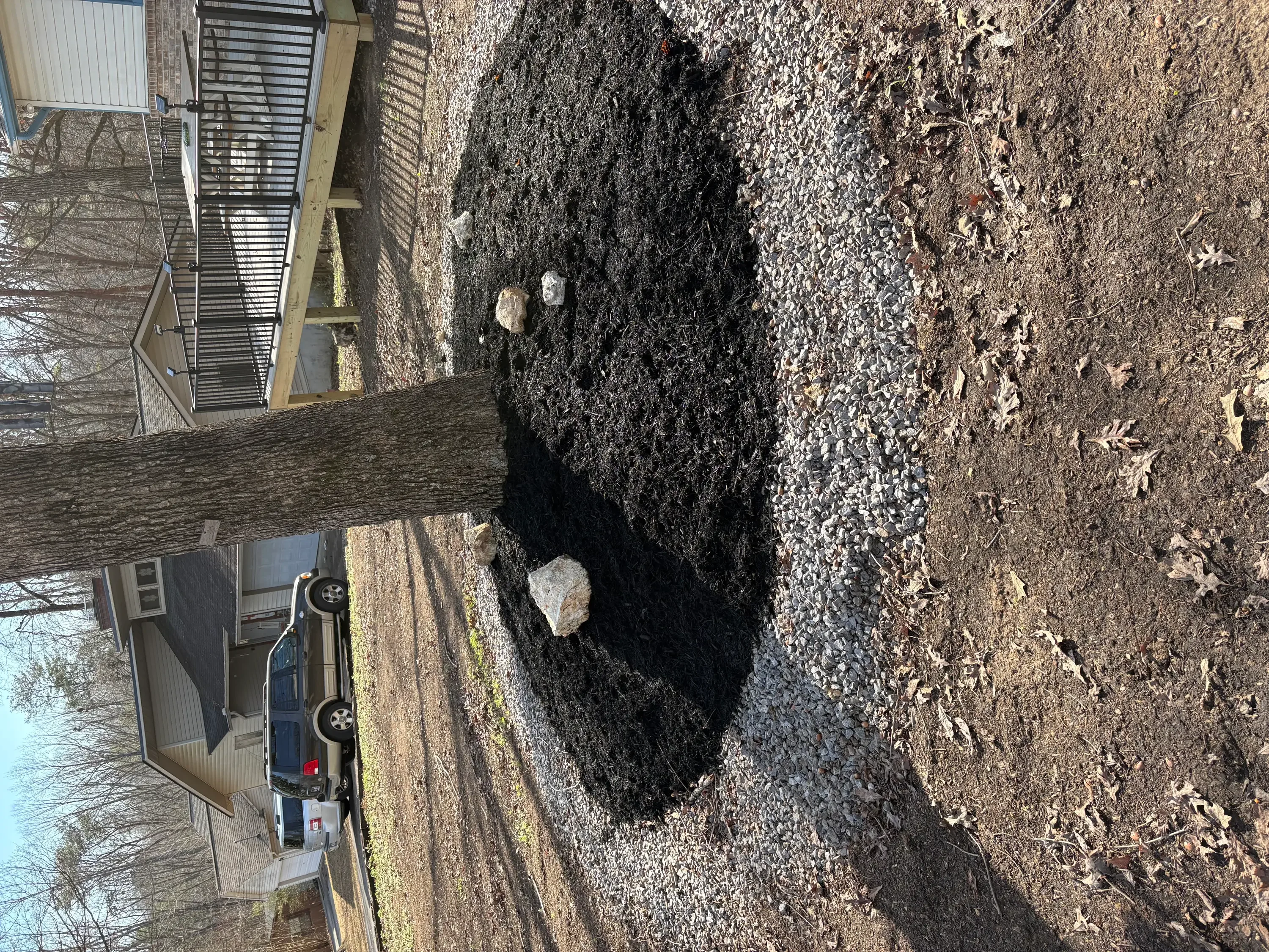 Asphalt driveway pothole repair with fresh patch material applied to damaged section