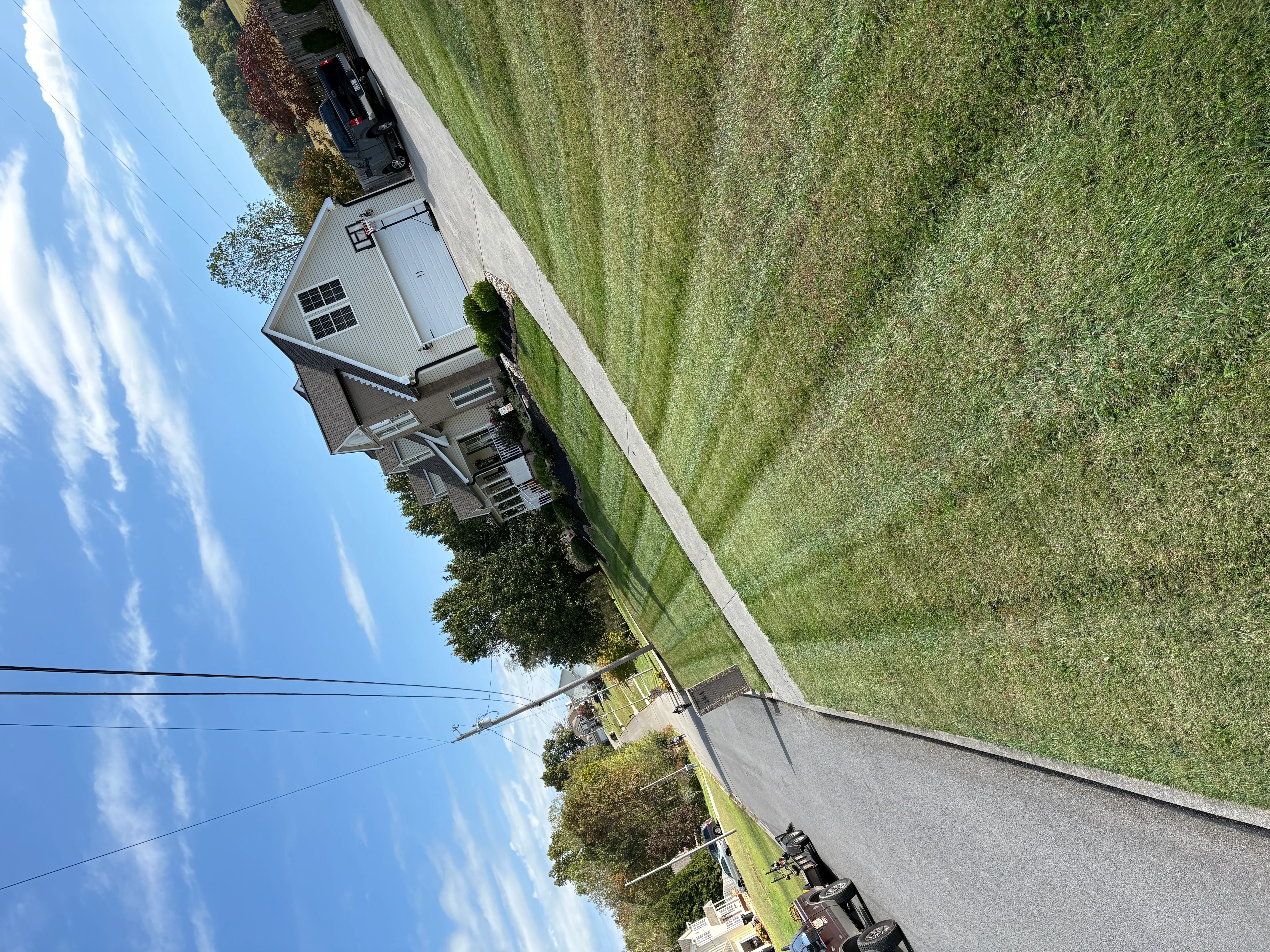 Newly installed concrete driveway at residential home with manicured lawn