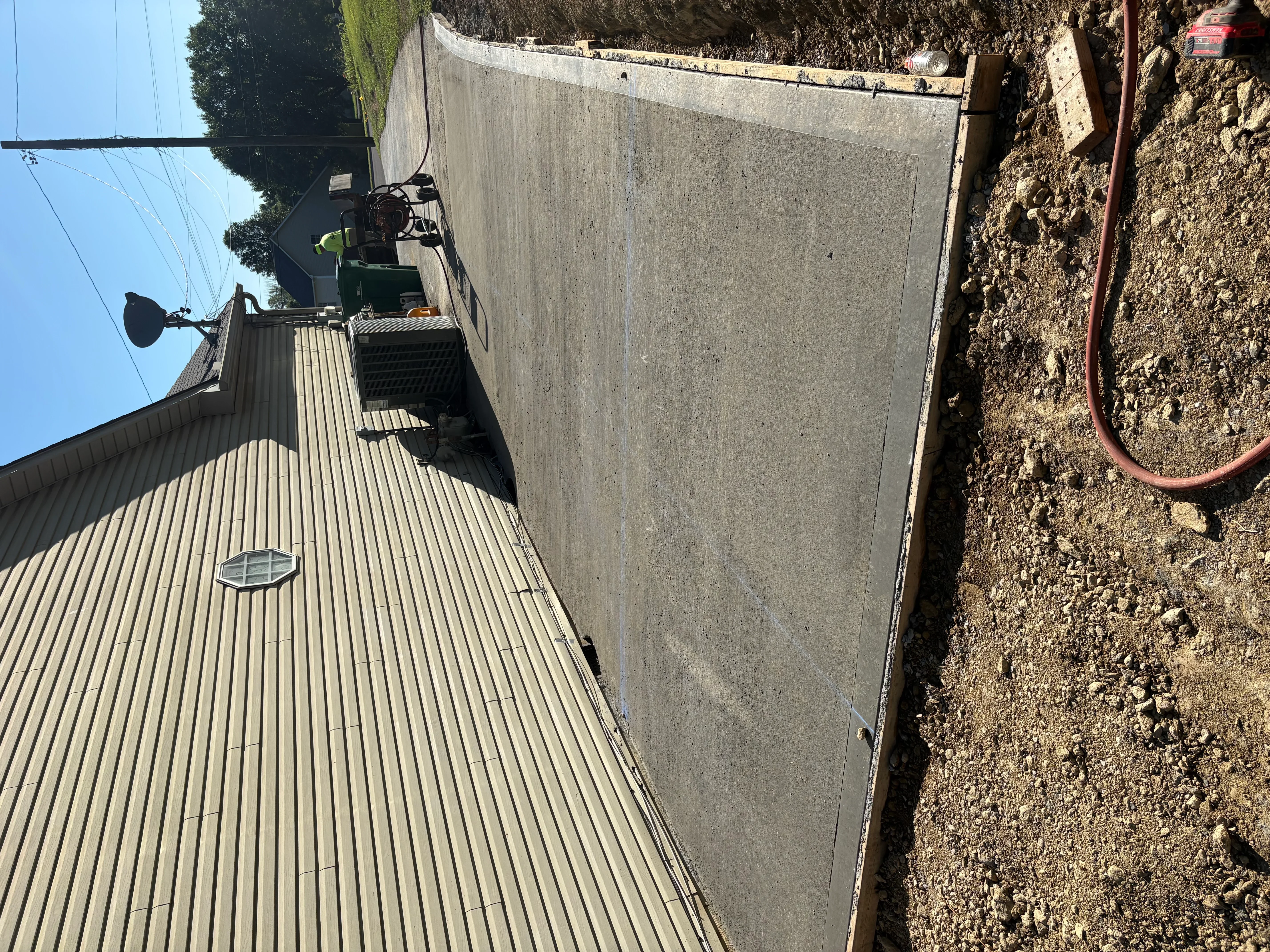Newly poured concrete driveway with metal edging and finished surface