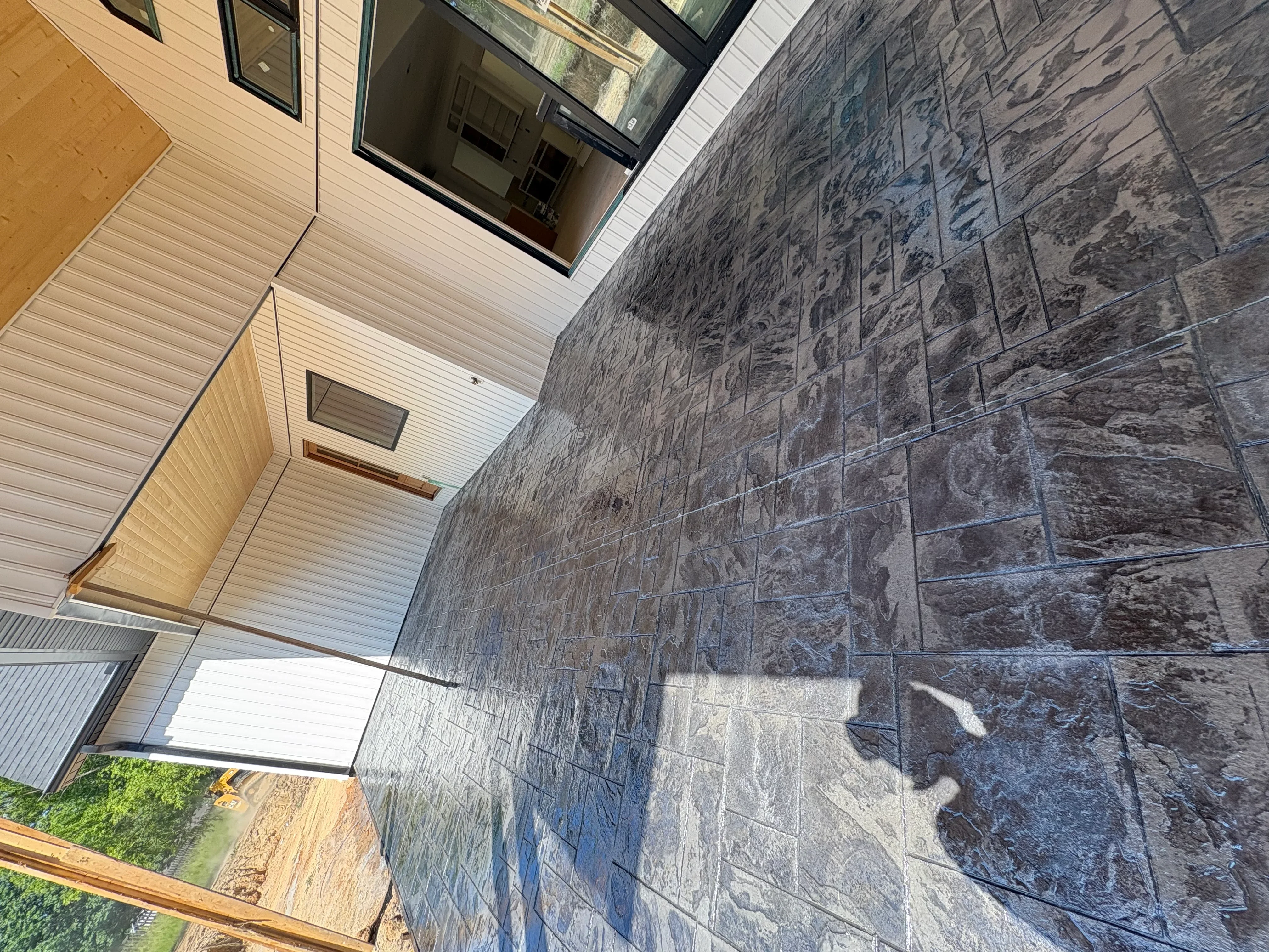 Stamped concrete patio with slate tile pattern next to residential home