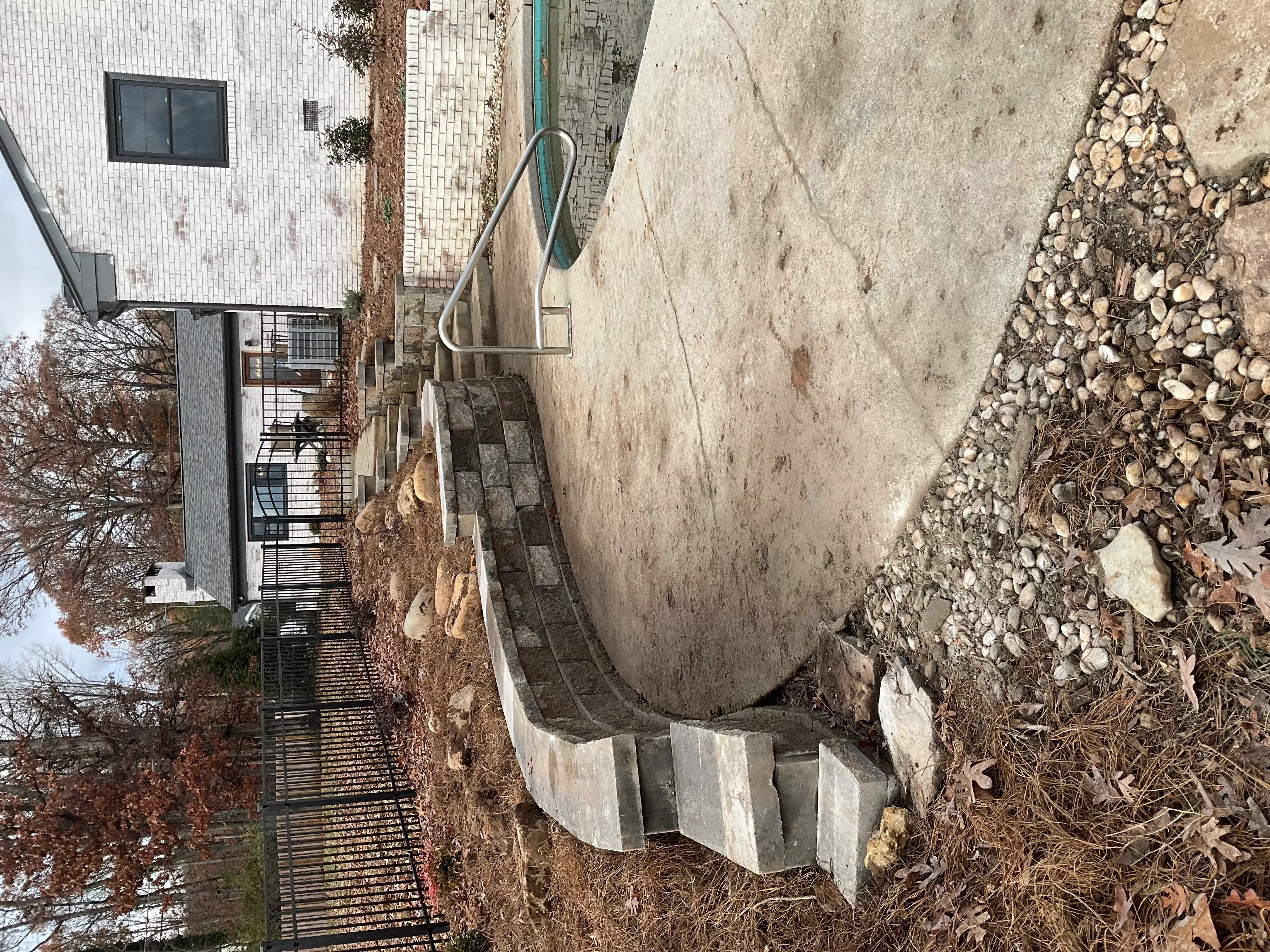 Concrete stairway with metal handrail and drainage system on residential slope