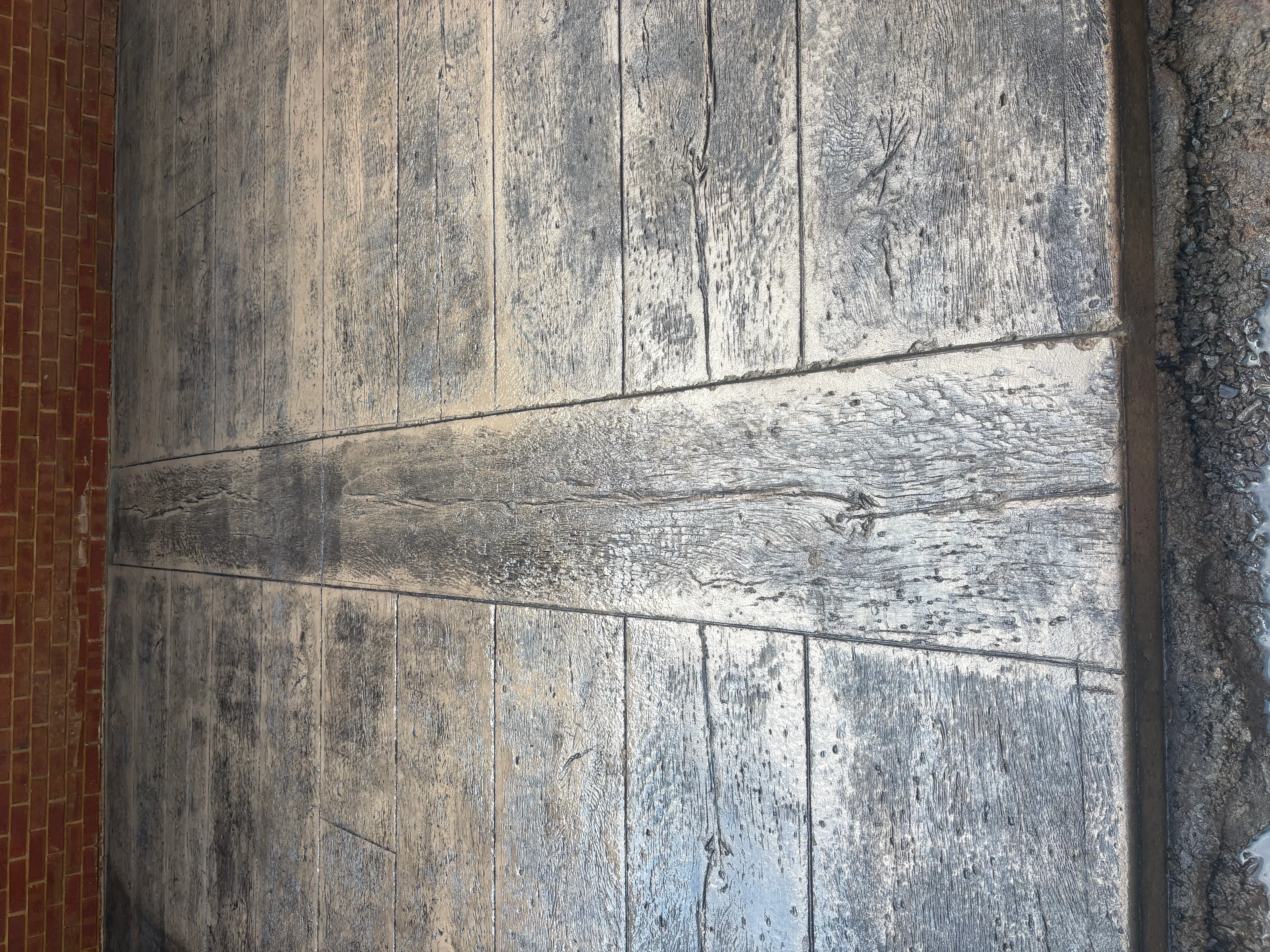 Weathered wood deck with pressure-washed section showing restored wood grain and color