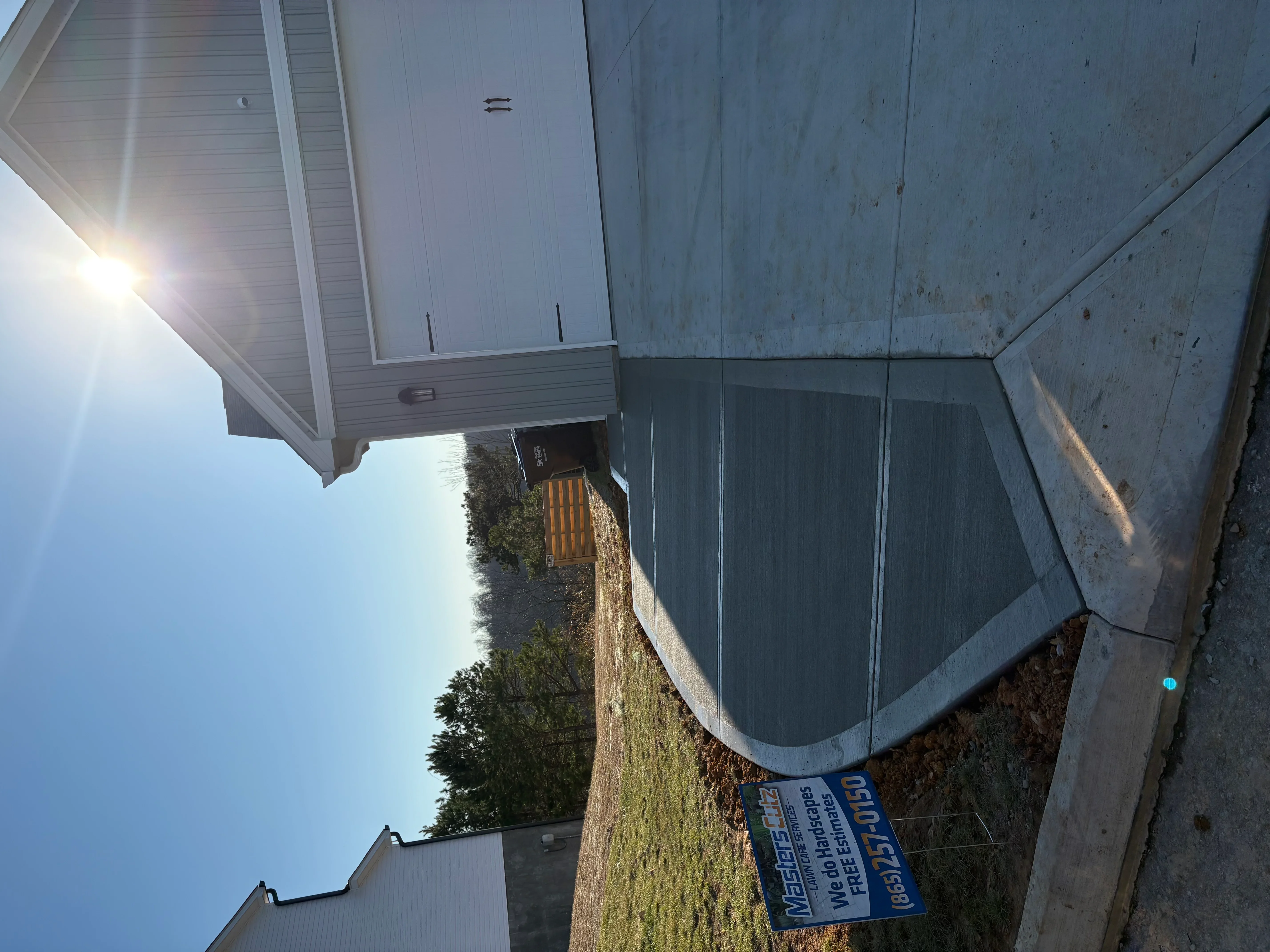 Finished concrete driveway and foundation with proper grading on residential property