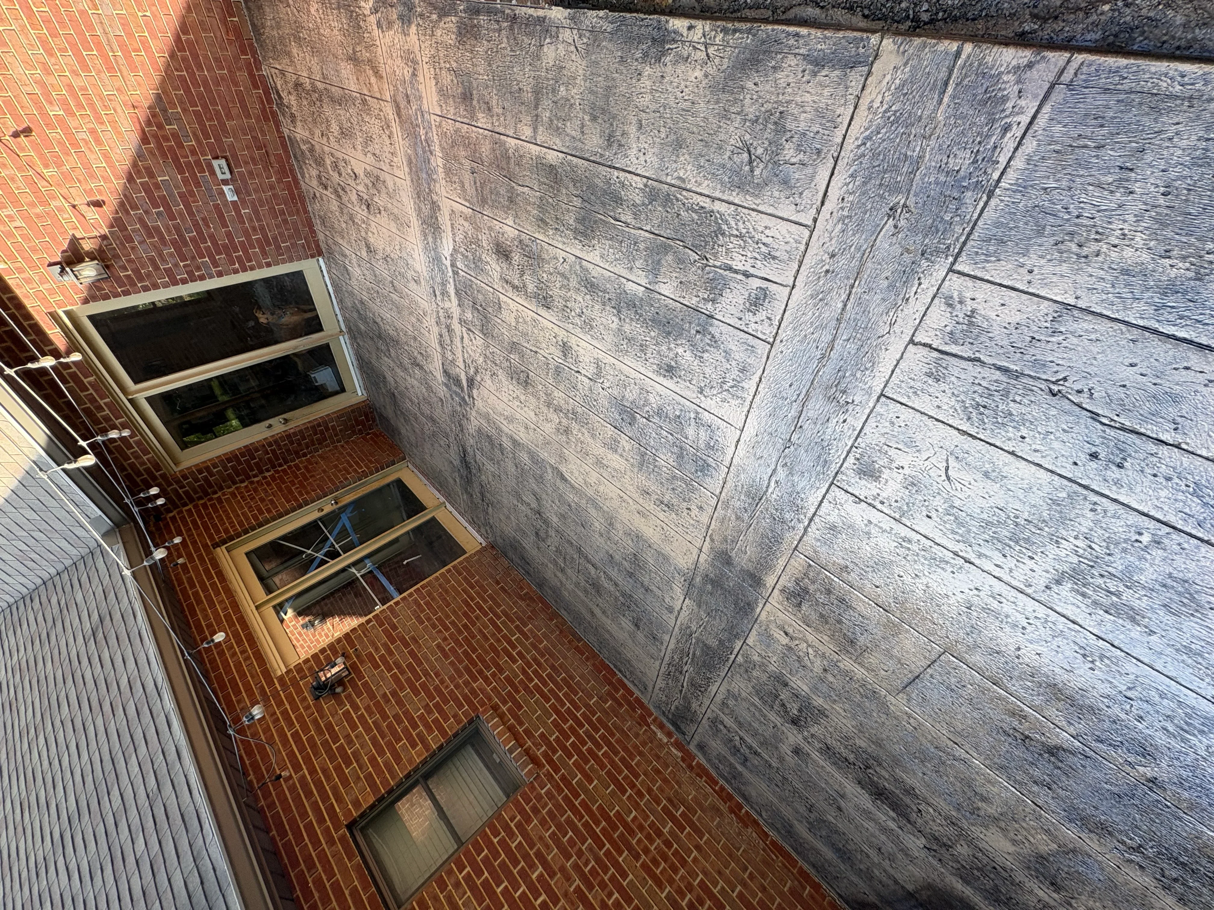 Cleaned concrete foundation wall next to brick exterior with basement windows