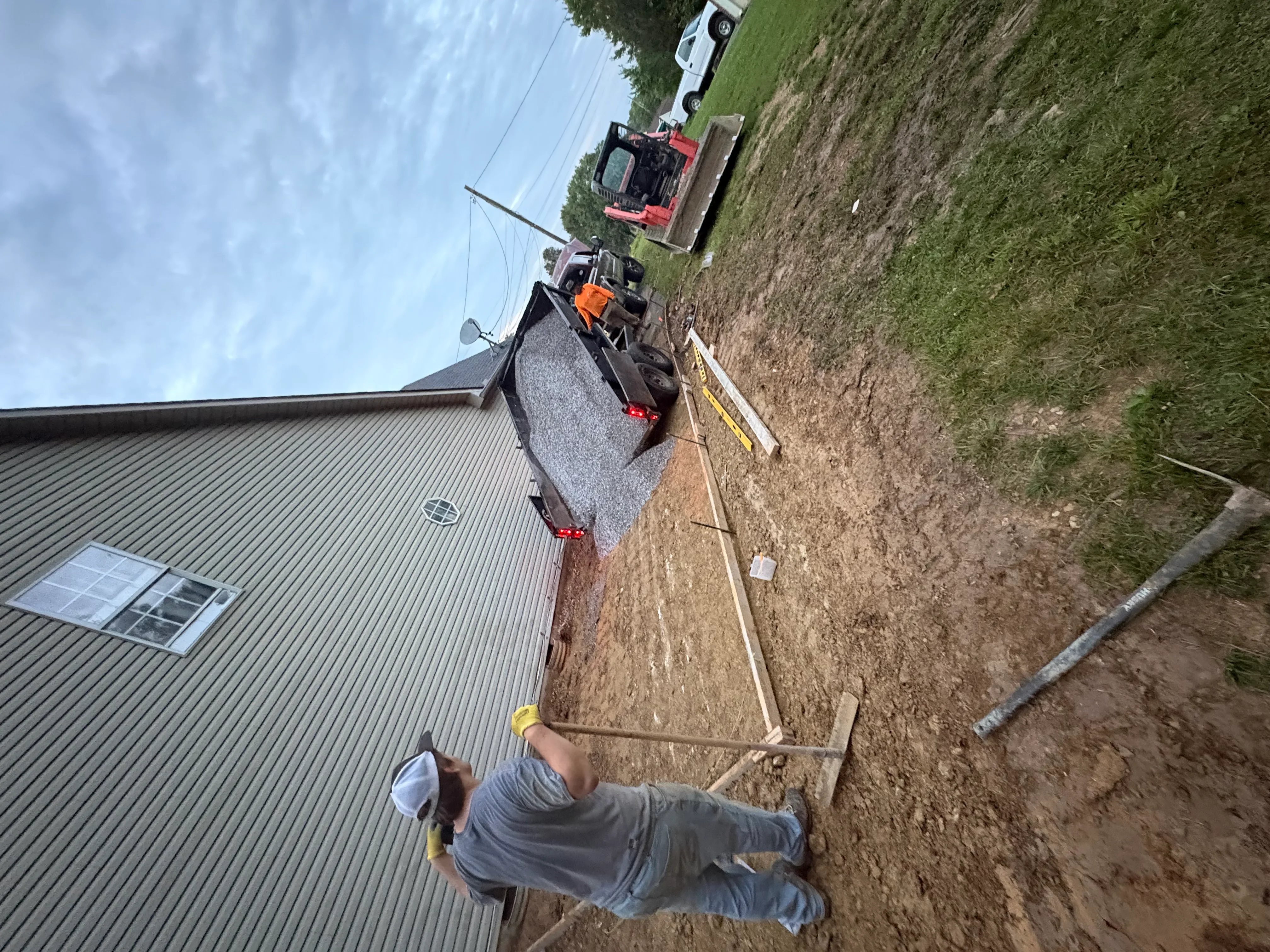 Concrete driveway installation with wooden forms and graded base material